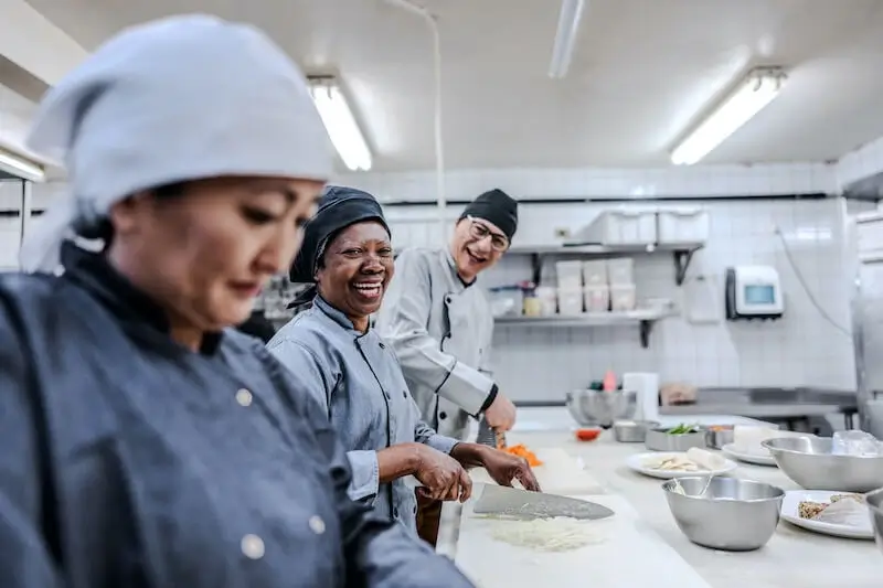 Culinary team working together in professional commercial kitchen.